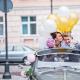 DIY-Dekoration der Motorhaube eines Hochzeitsautos – ähnliche Dekoration mit Blumen und Luftballons. Das Auto für die Hochzeit dekorieren
